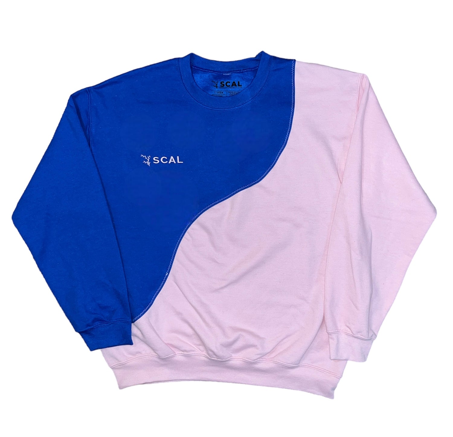 A pink and blue, 2-tone sweatshirt made with a unique seam line. Two pre-made sweatshirts were cut and upcycled into a one of a kind sweatshirt. It also has an embroidered SCAL logo. 